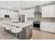 Well-lit kitchen showcasing stainless steel appliances, a large island with seating, and white cabinetry at 8634 Santa Cruz Dr, Port Charlotte, FL 33981