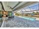 The screened-in pool area offers an outdoor dining set and views of the canal at 8634 Santa Cruz Dr, Port Charlotte, FL 33981