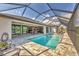 This screened in pool is flanked by views from the home and a water view beyond at 8634 Santa Cruz Dr, Port Charlotte, FL 33981