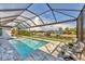 A luxurious screened-in pool with comfortable lounge chairs and picturesque canal views at 8634 Santa Cruz Dr, Port Charlotte, FL 33981