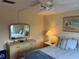 Serene bedroom with a queen size bed, wood floors, and a mirrored dresser, creating a peaceful retreat at 868 Baveno Dr, Venice, FL 34285