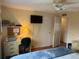 Cozy bedroom featuring a ceiling fan, desk with printer, and a mounted television at 868 Baveno Dr, Venice, FL 34285