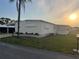 Charming manufactured home featuring a covered carport, well-maintained lawn, and mature landscaping at 868 Baveno Dr, Venice, FL 34285