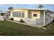 Charming manufactured home with a covered porch, white picket fence, and well-manicured lawn at 868 Baveno Dr, Venice, FL 34285