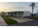 Well-maintained manufactured home with a covered carport and neat landscaping for curb appeal at 868 Baveno Dr, Venice, FL 34285