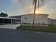 Charming manufactured home featuring a covered carport and well-maintained landscaping at 868 Baveno Dr, Venice, FL 34285