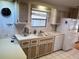 Compact kitchen features white cabinets, appliances, and ample counter space for efficient meal preparation at 868 Baveno Dr, Venice, FL 34285