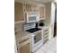 Cozy kitchen featuring white appliances and wooden cabinets, creating a warm and inviting cooking space at 868 Baveno Dr, Venice, FL 34285