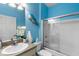 Bathroom with vanity, toilet, walk-in shower, and bright blue walls at 9118 Coachman Dr, Venice, FL 34293