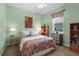Cozy bedroom with a patterned bedspread, carpeted floors, and window with blinds at 9118 Coachman Dr, Venice, FL 34293