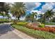 Beautiful Pennington Place community entrance with mature landscaping and blooming flower beds at 9118 Coachman Dr, Venice, FL 34293