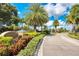 Community entrance with lush landscaping, a manicured flower beds, and signage at 9118 Coachman Dr, Venice, FL 34293