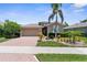 Charming home featuring a brick driveway, meticulously manicured landscaping, and a two-car garage at 9118 Coachman Dr, Venice, FL 34293