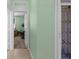 Hallway with tiled floor leading to rooms with neutral-colored walls at 9118 Coachman Dr, Venice, FL 34293