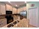 Kitchen features stainless steel appliances, granite countertops, and sleek white cabinetry at 9118 Coachman Dr, Venice, FL 34293