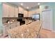 Bright kitchen featuring stainless steel appliances, granite countertops, and spacious cabinetry at 9118 Coachman Dr, Venice, FL 34293