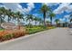 Entrance to Pennington Place featuring a stone sign, manicured landscaping, and palm trees along a paved street at 9118 Coachman Dr, Venice, FL 34293