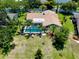 An aerial view of a home featuring a screened pool, lush landscaping, and a well-maintained lawn in a desirable neighborhood at 915 S Doral Ln, Venice, FL 34293