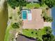 A home boasts mature landscaping, a screen enclosed pool, and possible water access, as seen from this aerial view at 915 S Doral Ln, Venice, FL 34293