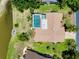A home boasts mature landscaping, a screen enclosed pool, and possible water access, as seen from this aerial view at 915 S Doral Ln, Venice, FL 34293