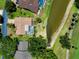 Aerial view of home with a private pool and mature landscaping, adjacent to a water feature and golf course at 915 S Doral Ln, Venice, FL 34293
