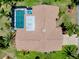 An aerial view of a roof atop a home featuring a pool and tropical landscaping, highlighting privacy and outdoor living at 915 S Doral Ln, Venice, FL 34293