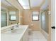 Bright bathroom featuring a shower, tile flooring, and a cream-colored vanity at 915 S Doral Ln, Venice, FL 34293