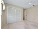 Neutral bedroom featuring carpet, ceiling fan and large closet with bi-fold doors at 915 S Doral Ln, Venice, FL 34293