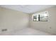 Neutral bedroom featuring carpet, ceiling fan and large window with sheer curtains at 915 S Doral Ln, Venice, FL 34293