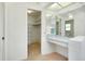 Bright dressing area featuring a vanity, ample lighting, and a walk-in closet for storage at 915 S Doral Ln, Venice, FL 34293