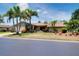 Inviting single-story home with lush landscaping, towering palms, and an attached garage viewed from across the street at 915 S Doral Ln, Venice, FL 34293