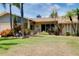 Charming single-story home with a lush lawn and manicured landscaping featuring mature palm trees and a visible house number at 915 S Doral Ln, Venice, FL 34293
