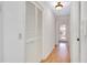 Hallway with wood floors, a closet with louvered doors, and access to the front door at 915 S Doral Ln, Venice, FL 34293