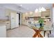 Eat-in kitchen with a glass-topped table, white cabinets, and a view of the kitchen at 915 S Doral Ln, Venice, FL 34293