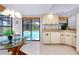 Eat-in kitchen with a glass-topped table, white cabinets, and a view of the pool at 915 S Doral Ln, Venice, FL 34293