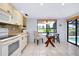 Eat-in kitchen with a glass-topped table, white tile floor, and a view of the golf course at 915 S Doral Ln, Venice, FL 34293