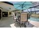 Comfortable outdoor lanai with seating under a blue umbrella by a pool at 915 S Doral Ln, Venice, FL 34293
