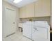 Well-lit laundry room with washer, dryer, utility sink, and ample cabinet storage at 915 S Doral Ln, Venice, FL 34293