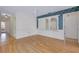 Open living space with wood floors, white wainscoting, and decorative mirror and wallpaper at 915 S Doral Ln, Venice, FL 34293