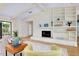Inviting living room with fireplace, built-ins, wood flooring, and a view of the backyard at 915 S Doral Ln, Venice, FL 34293