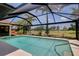 Sparkling swimming pool with screened enclosure, offering serene views of palm trees at 915 S Doral Ln, Venice, FL 34293