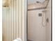 Tiled shower with silver showerhead, and patterned wallpaper in a tranquil bathroom at 915 S Doral Ln, Venice, FL 34293