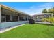 Well-maintained backyard featuring lush lawn, patio with furniture, and screened-in pool area at 9277 Saint Catherine Ave, Englewood, FL 34224