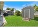 Lush backyard featuring green grass, pool with screened enclosure, and a storage shed perfect for all your outdoor tools at 9277 Saint Catherine Ave, Englewood, FL 34224