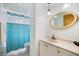 Bathroom featuring a vanity, a decorative oval mirror, and a shower with a turquoise curtain at 9277 Saint Catherine Ave, Englewood, FL 34224