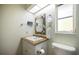 Well-lit bathroom with a decorative mirror, white vanity, updated fixtures, and a beachy themed decoration at 9277 Saint Catherine Ave, Englewood, FL 34224