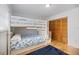 Comfortable bedroom with a bunk bed, staircase storage, and a closet with wooden doors at 9277 Saint Catherine Ave, Englewood, FL 34224