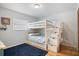 Cozy bedroom featuring a bunk bed with stairs and storage, complemented by a navy rug at 9277 Saint Catherine Ave, Englewood, FL 34224