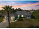 Charming blue home with stone accents, well-manicured lawn, and mature palm tree, radiating curb appeal at 9277 Saint Catherine Ave, Englewood, FL 34224