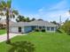 Charming single-story home with blue siding, stone accents, well-manicured lawn, and a palm tree in the front yard at 9277 Saint Catherine Ave, Englewood, FL 34224